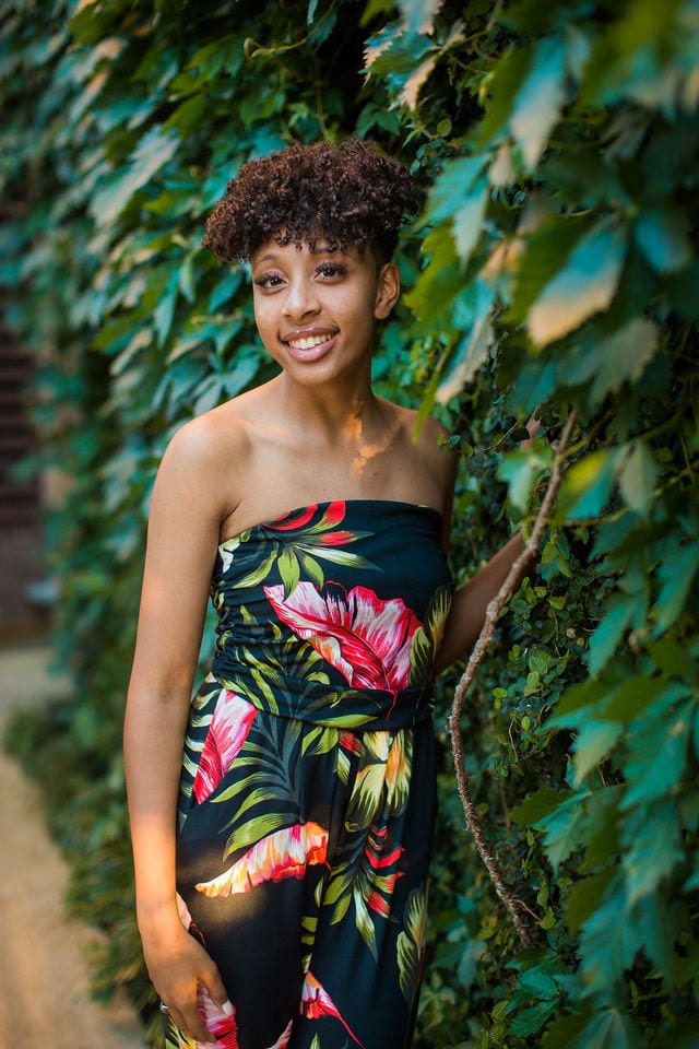 Maykahla's senior session the Pearl smiling on ivy wall