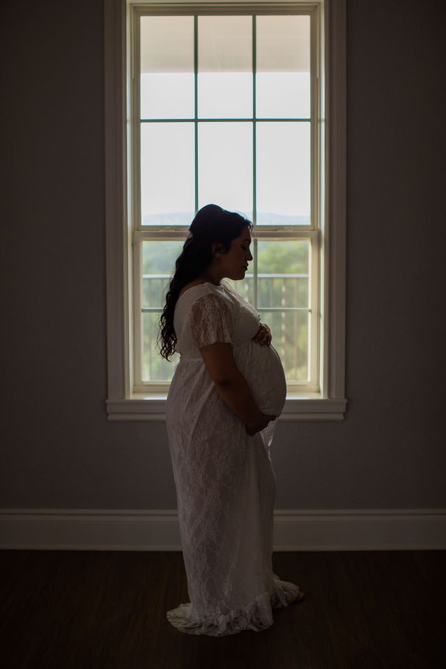 Emilia maternity session Kendall Pointe in the window holding belly