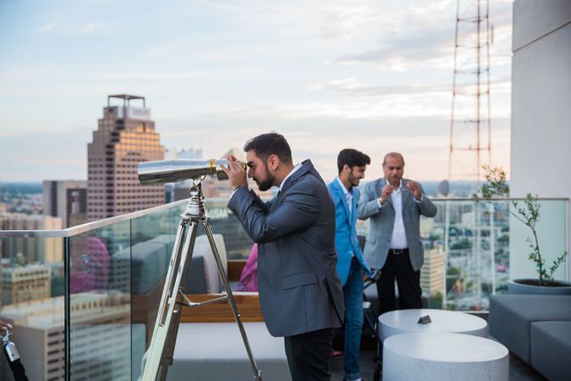 Kunal proposal at the Thompson Hotel, him looking though the binoculars