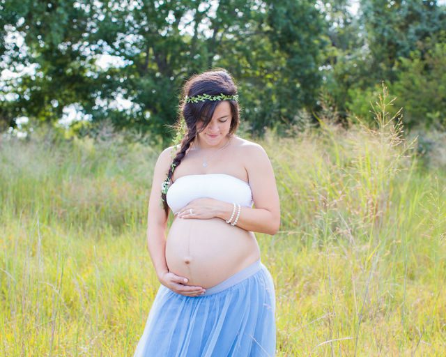 Stefan maternity Cibolo Natural Area Ashley in tutu in the grass holding baby