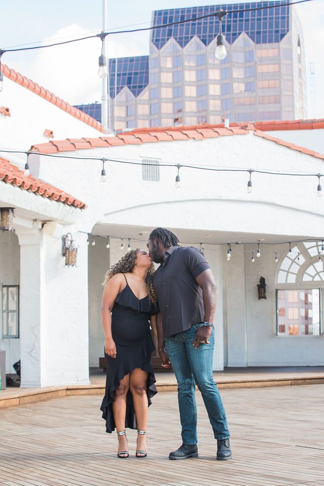 Dominic engagement session at St Anthony on the rooftop kissing with lights