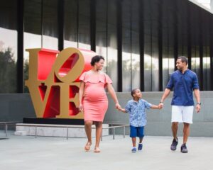 Shara maternity McNay Art Museum waling by the Love sign