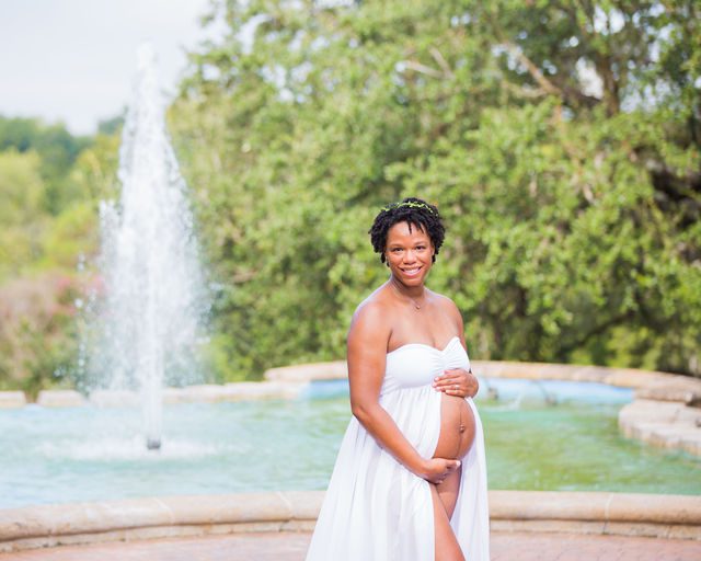 Shara maternity McNay Art Museum white dress in front of the fountain close