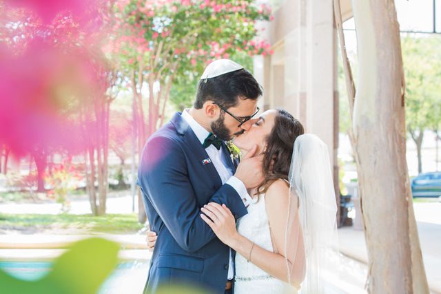 Ophir wedding in San Antonio couple kiss by the fountain with flowers