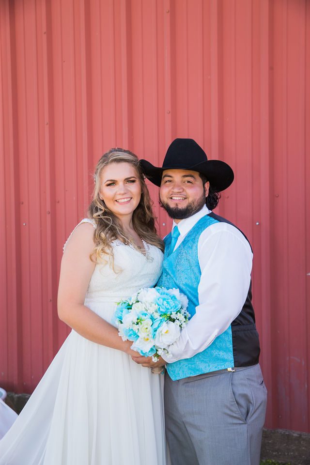 The Olivarez couple at the wedding at the Copper Door on the red wall