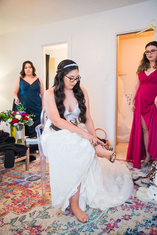 Bethany putting on her shoes at her wedding at Los Encinos