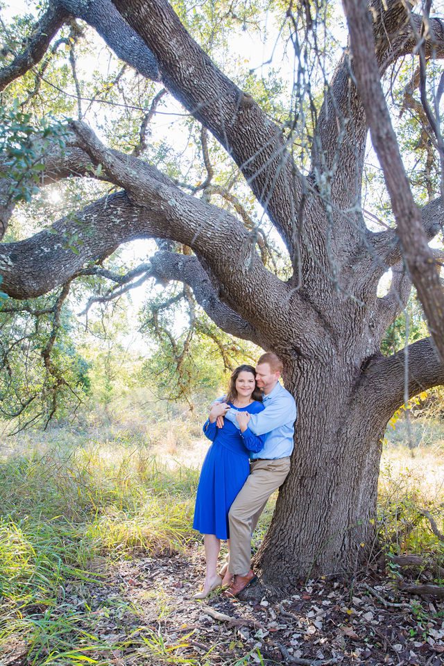 Coltan and Stephanie engagement under the tree at Cibolo Natural Area looking up