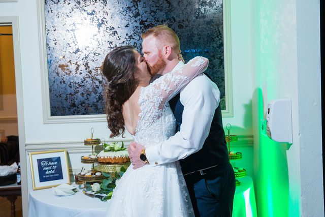 Stephanie's wedding reception at the Kendall Inn cake cutting kiss