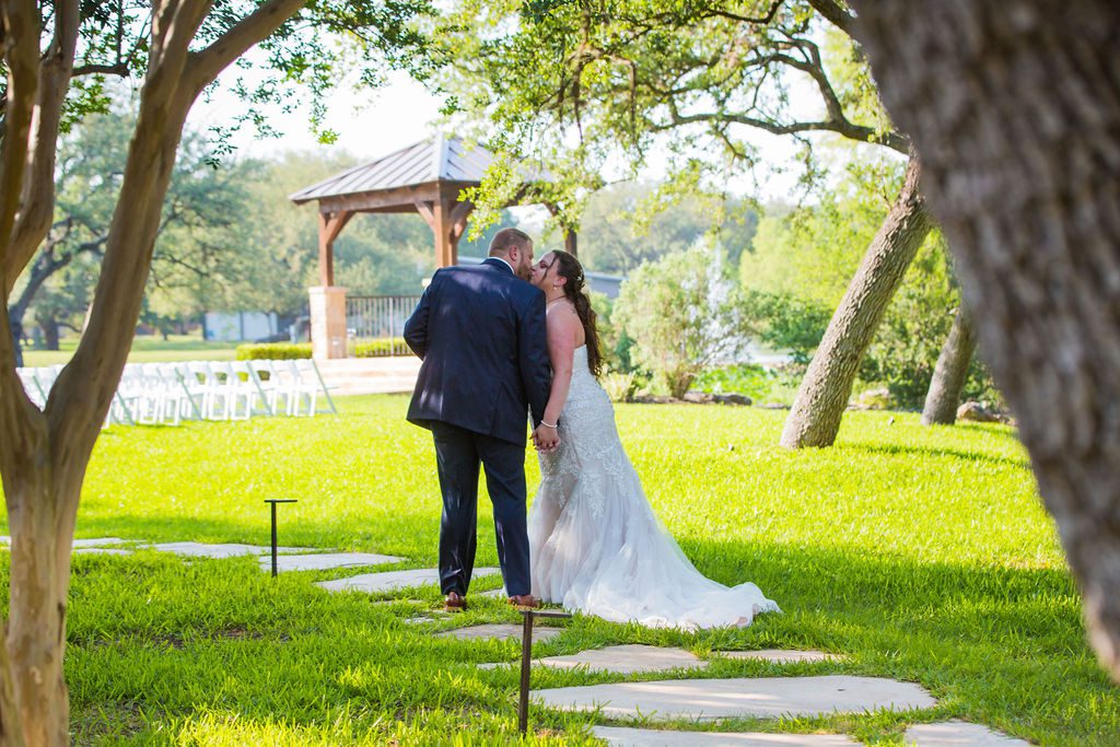 Jenny's wedding at the Club at Garden Ridge couple's kiss on the path