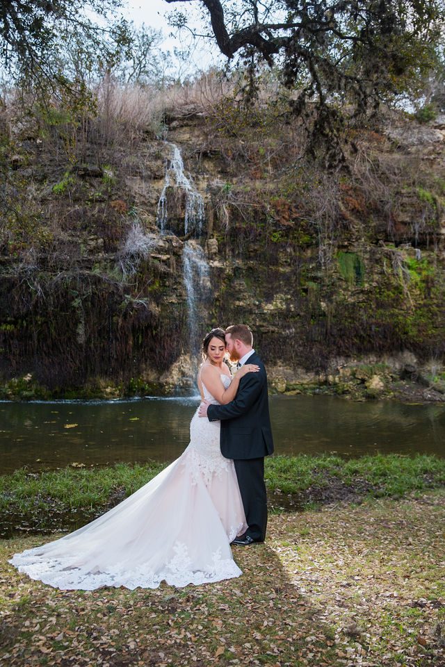 Yoli and Daltin's wedding at Canyon Springs in front of the waterfall romantic portrait