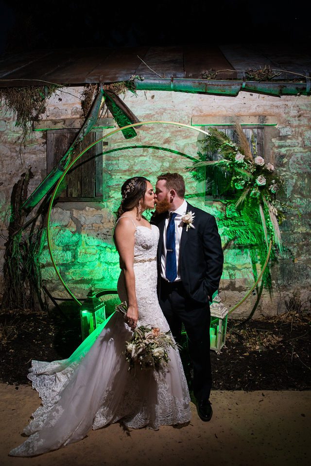 Yoli and Daltin night kiss at the arch at their wedding at Canyon Springs