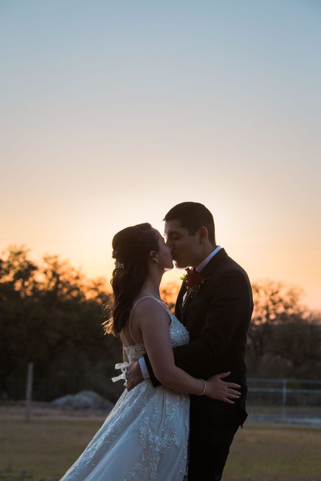 Allison's wedding at Hofmann Ranch sunset portrait close with kiss