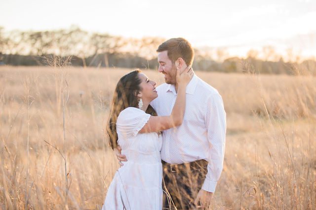 Bethany and Adam engagement hugging in the grass at Cibolo Natural Area