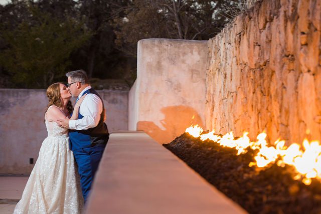 Deborah's Lost Mission wedding bride and groom kiss by the firewall