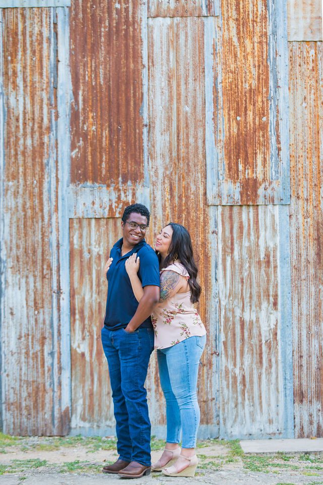 Elexes engagement portrait in Gruene standing by the tin wall
