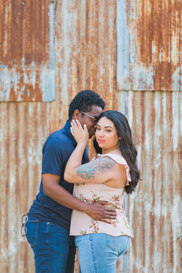Elexes engagement portrait in Gruene hugging by the tin wall