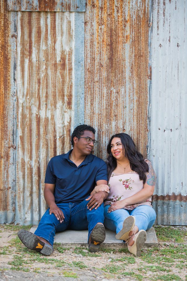 Elexes engagement portrait in Gruene sitting by the tin wall