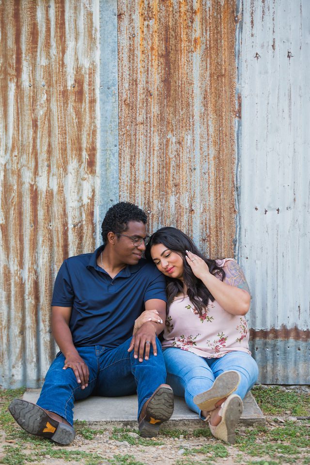 Elexes engagement portrait in Gruene loving by the tin wall