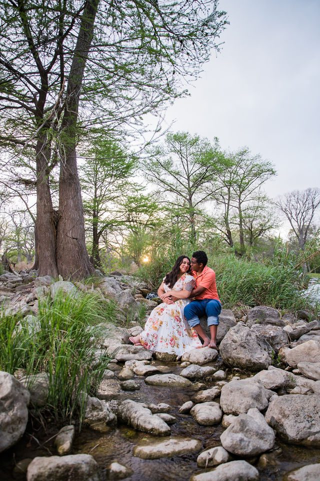 Elexes engagement portrait in Gruene sitting by the river