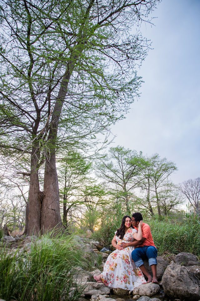 Elexes engagement portrait in Gruene sitting and snuggling by the river
