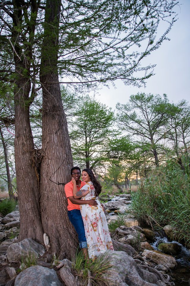 Elexes engagement portrait in Gruene leaning on a tree by the river