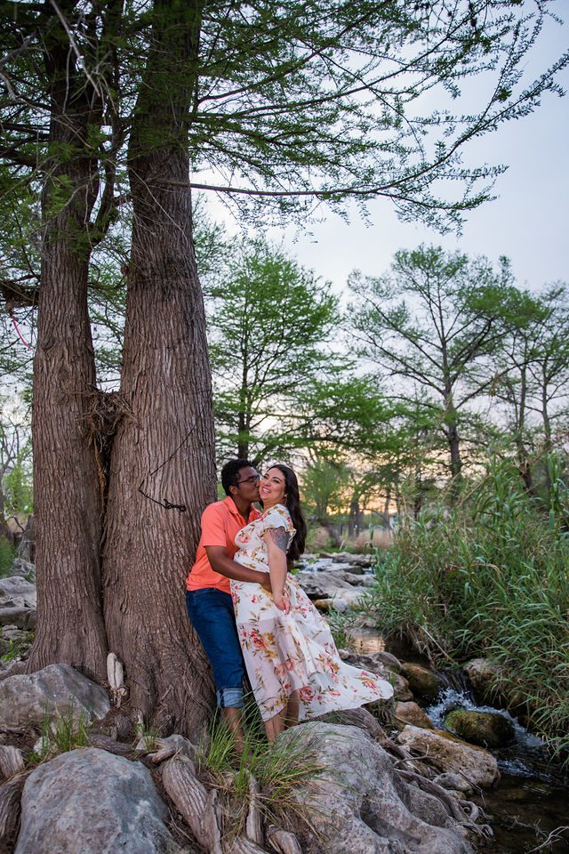 Elexes engagement session in Gruene kiss by the river against a tree