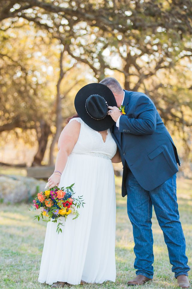 Liz's wedding at Enchanted Springs Ranch hidden kiss in the grass