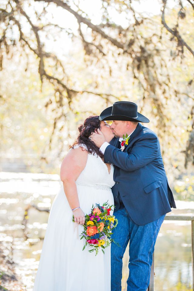 Liz's wedding at Enchanted Springs Ranch kiss on the bridge