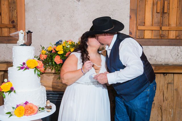 Liz's wedding at Enchanted Springs Ranch cake feeding kiss