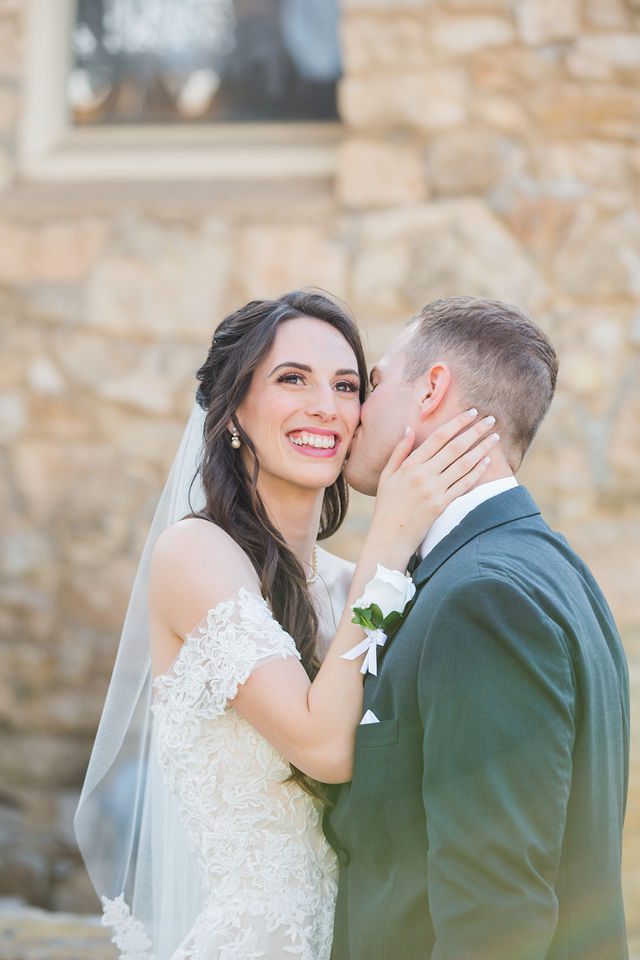Graysen wedding in Comfort couple kiss on the limestone wall