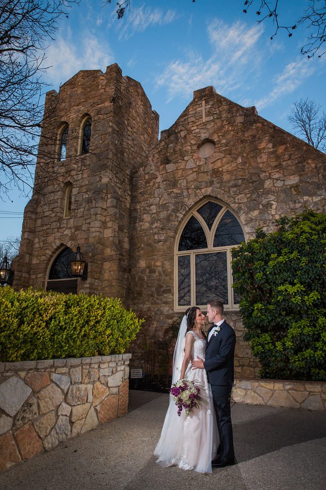 Graysen wedding ceremony in Comfort couple portrait in front of the chapel at sunset