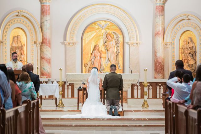 Kylee's wedding at OLLU Scared Heart Chapel bride & groom ceremony kneeling
