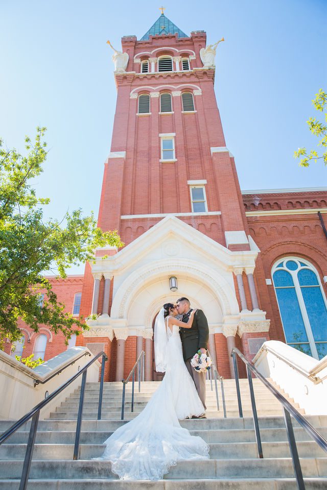 Kylee's wedding at OLLU Scared Heart Chapel couple portrait on the stairs with the steeple