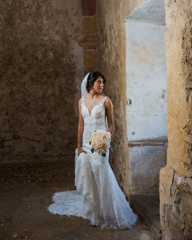 Kylee's bridal at Mission San Jose bride at the granary window walking away