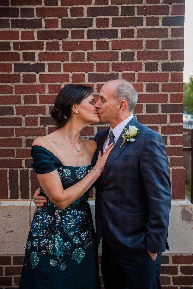 Sharon wedding in New Braunfels at McAdoos couple kiss on brick wall