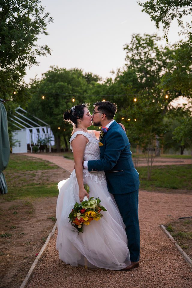 The Cruz-Martinez wedding reception in San Antonio kiss on the path
