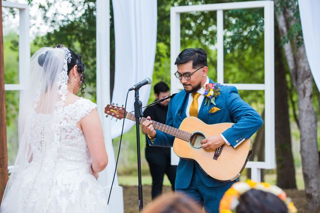 The Cruz-Martinez wedding in San Antonio the groom plays guitar during ceremony