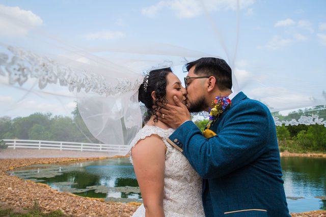 The Cruz-Martinez wedding in San Antonio couple under the veil by the pond