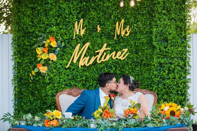 The Cruz-Martinez wedding in San Antonio reception kiss at the table