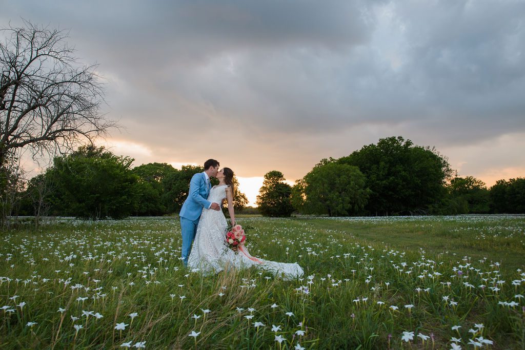 The Hamet wedding in San Antonio couple kissing in the dew drops at sunset