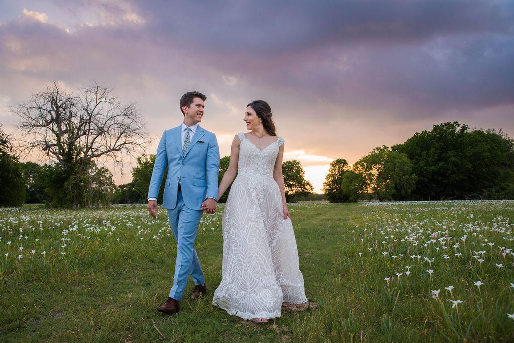 The Hamet wedding in San Antonio couple walking in the dew drops at sunset