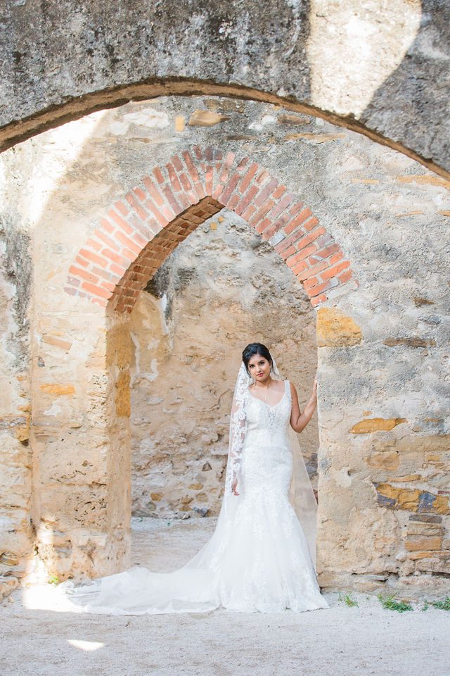 Sonali's bridal session in the doorway arch of Mission San Jose wedding gown