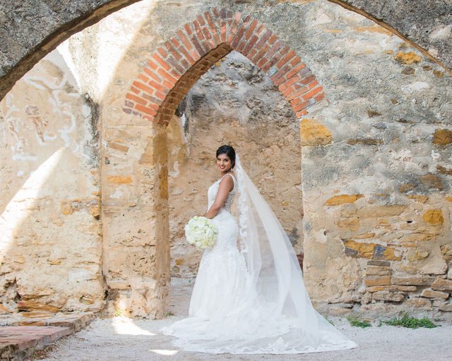 Sonali's bridal session in the doorway arch of Mission San Jose back of dress