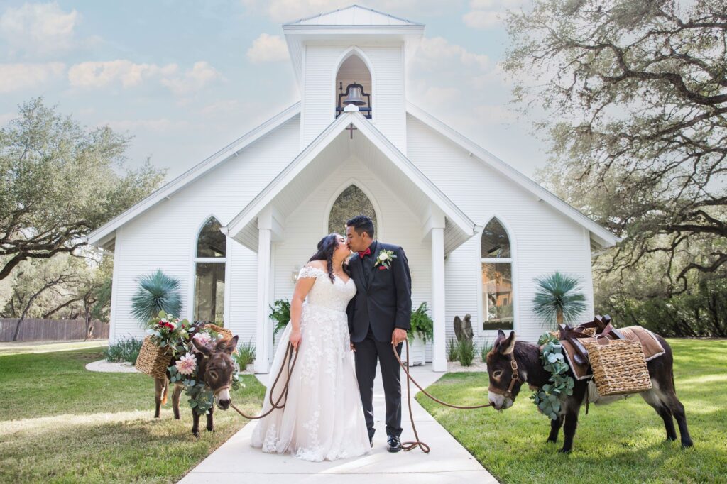 Hall wedding Chandelier of Gruene kiss in front of the chapel with the burros