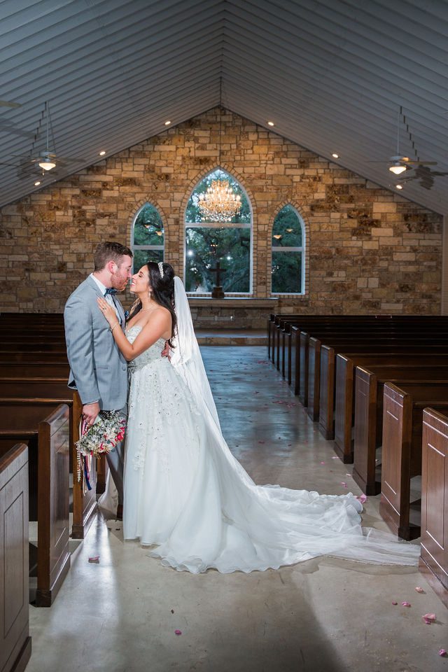 Weyand wedding at the Chandelier of Gruene. The couple kiss in the chapel
