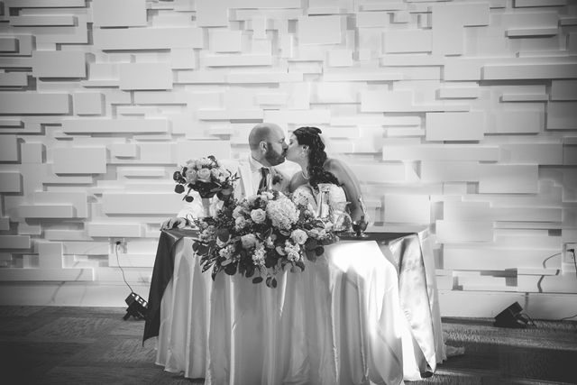 Tate wedding at Olympia Hills reception head table kiss