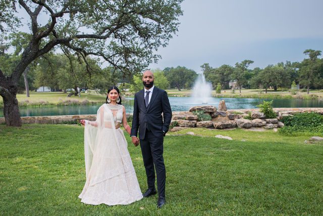 Nida wedding Club of Garden Ridge in San Antonio by the fountain holding hands