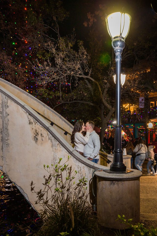 Ashlyn engagement in San Antonio Riverwalk kiss on the bridge under the light post