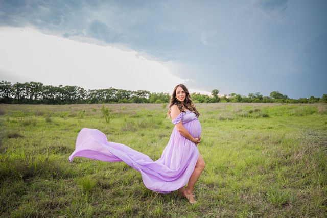 Yoli maternity session at Cibolo Natural Area mom in the grass with the storm