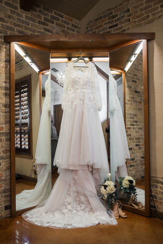Ryanne's Wedding at the Chandelier of Gruene the dress hanging in the bridal suite